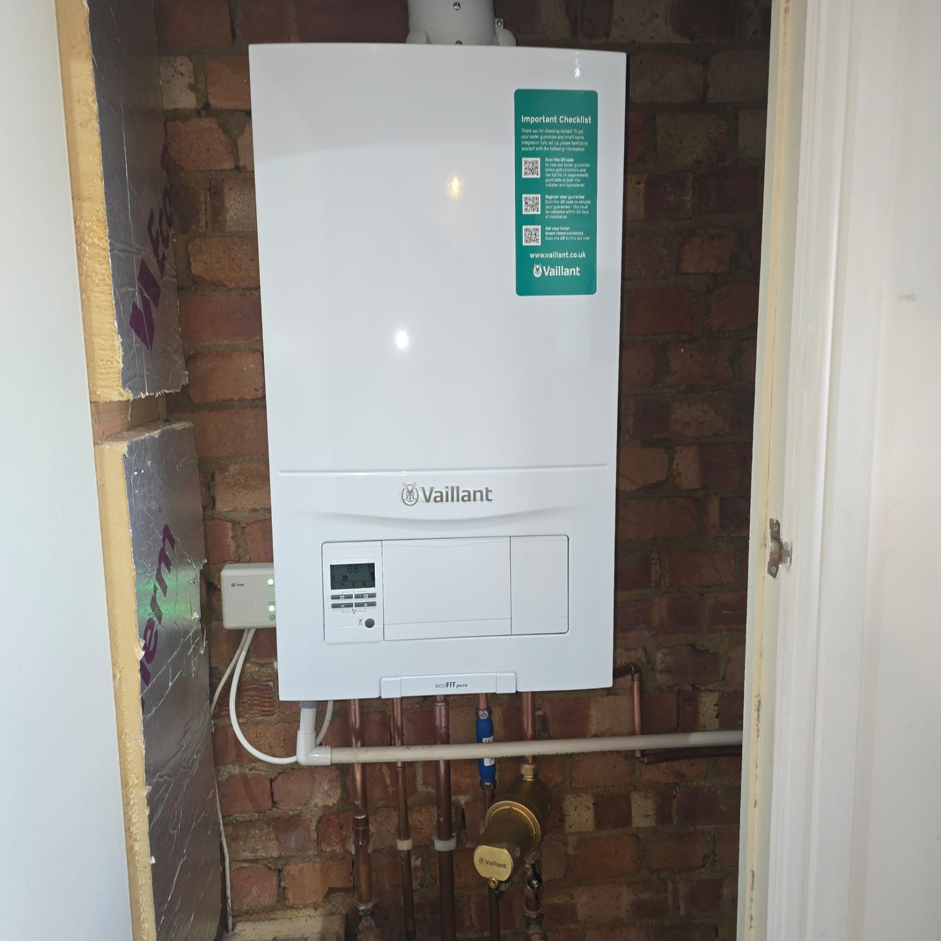 Boiler installed in a cupboard with exposed brickwork and insulation panels