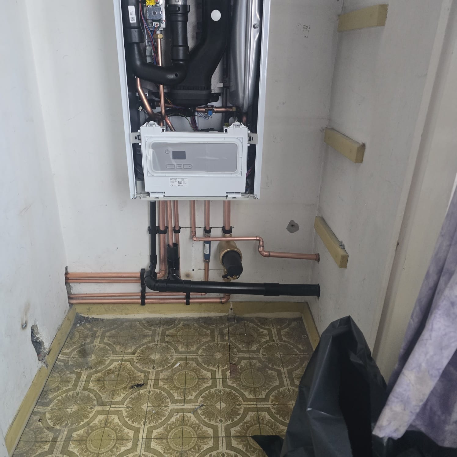 Combi boiler installation in a cupboard with copper flow and return pipework and condensate run