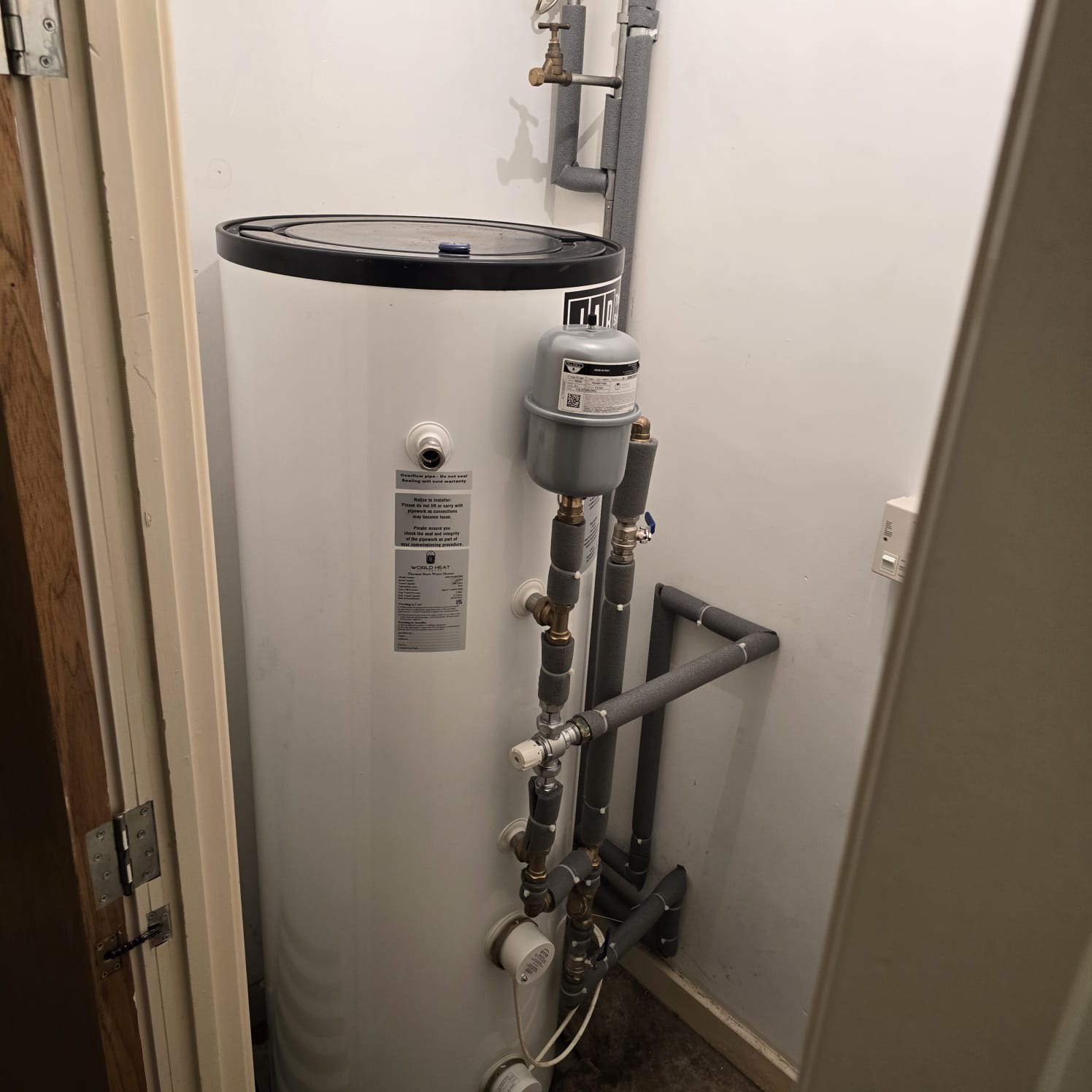 Unvented hot water cylinder with expansion vessel and insulated primary pipework