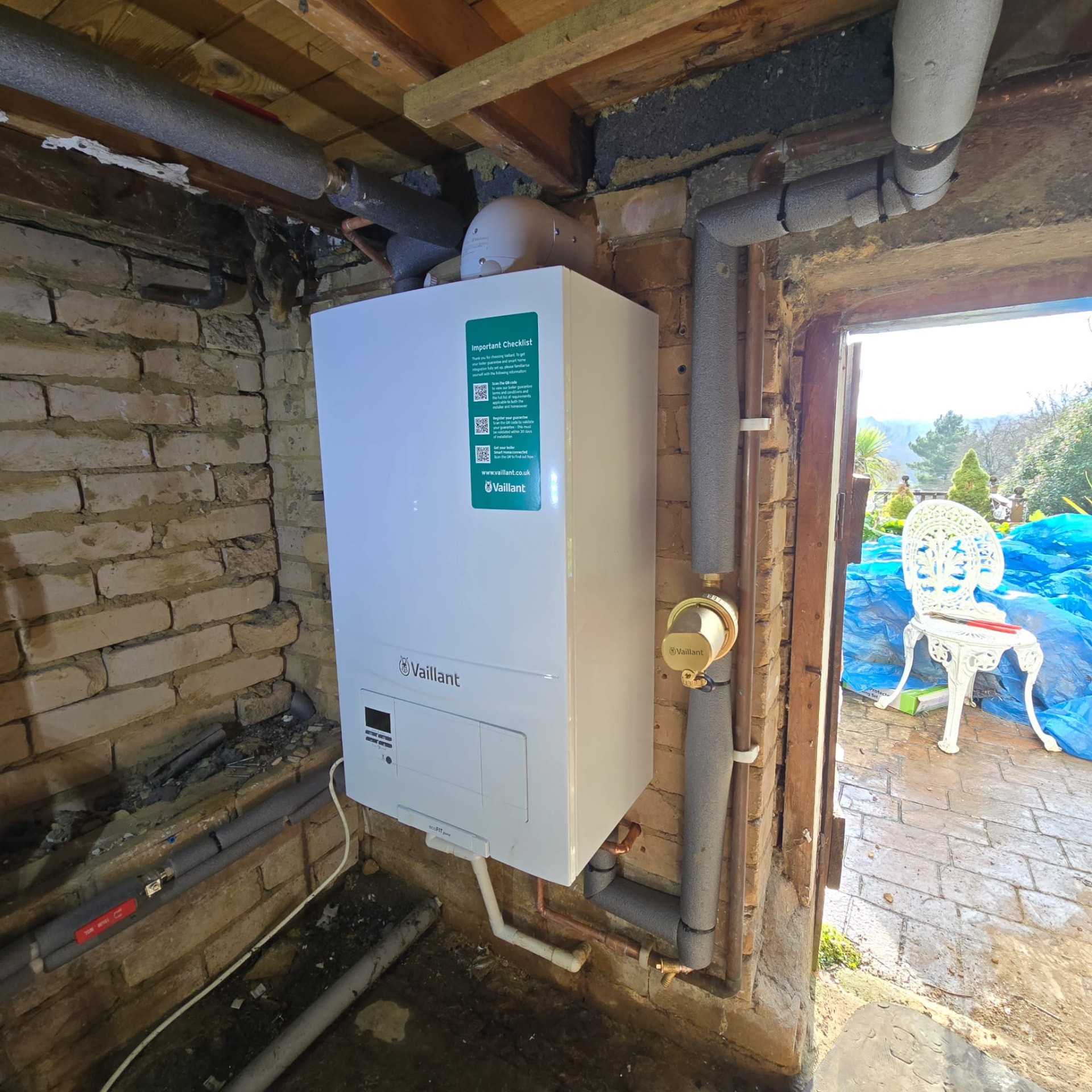 Boiler installed in a brick outbuilding with weather-protected flue and pipework