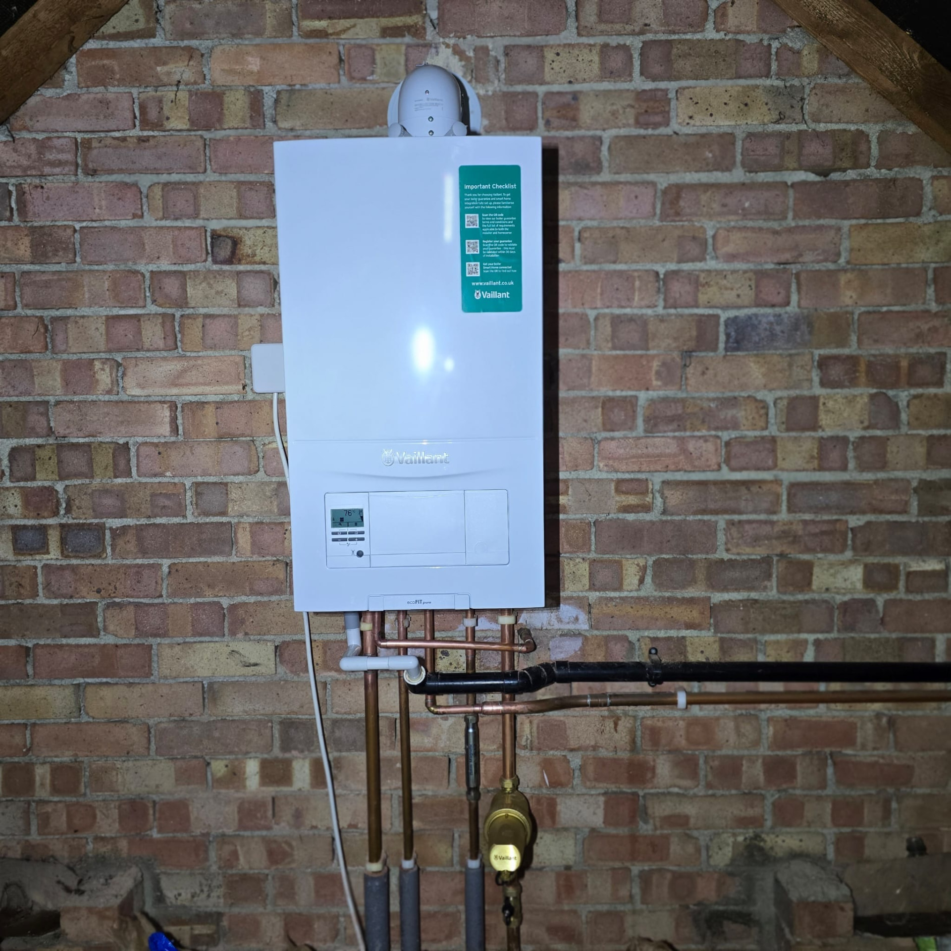 Loft boiler installation showing horizontal pipe runs from a Vaillant combi boiler